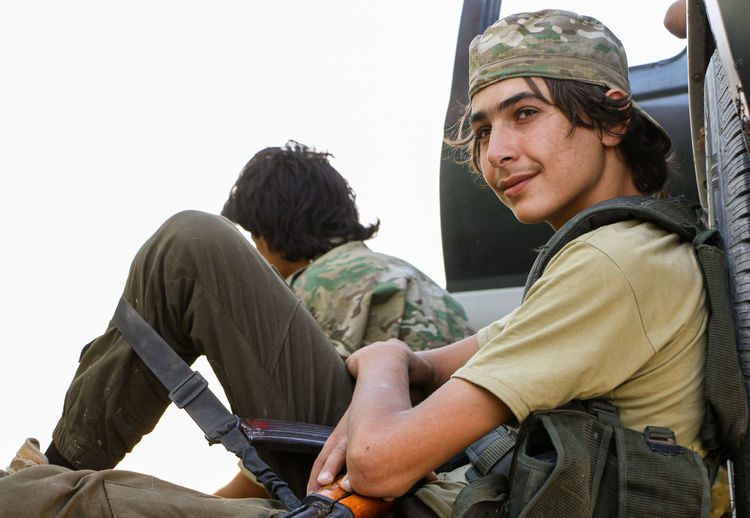 Side view of young man sitting outdoors