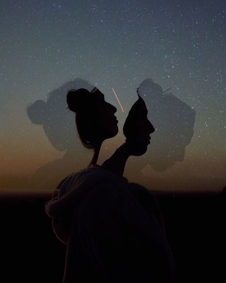Multiple image of silhouette woman against star field at night
