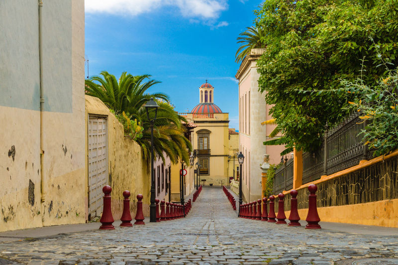 Empty footpath amidst buildings in city