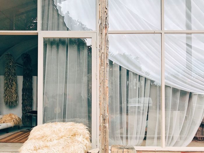 Vintage white curtains behind old glass window 