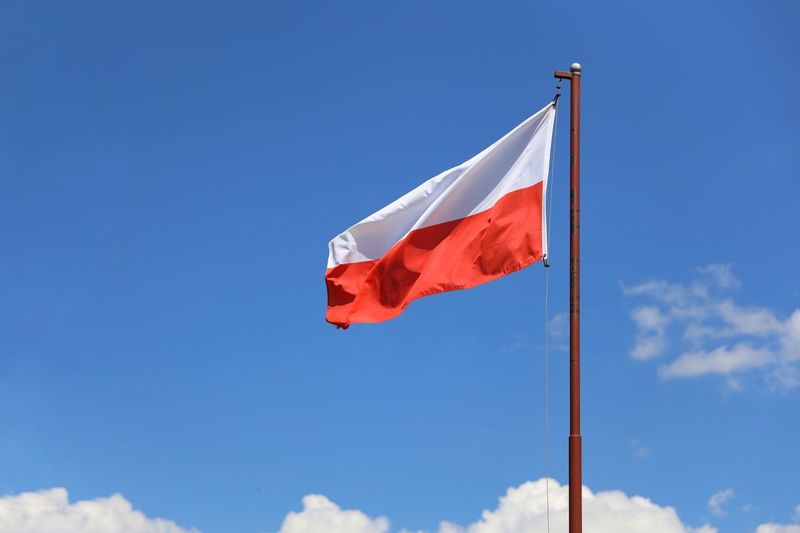 Polish flag against a clear blue sky