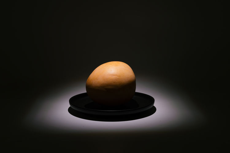 Close-up of tea light bulb on table against black background