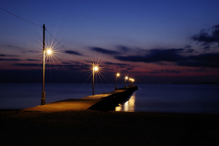 Streetlights on jetty over river