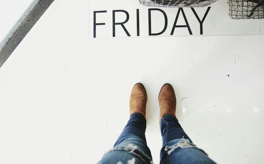 Low section of person standing on floor with friday text