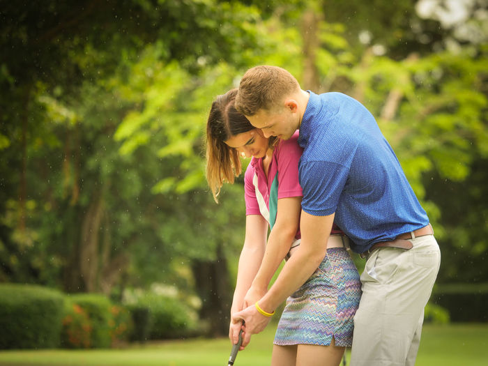 Couple playing golf at course