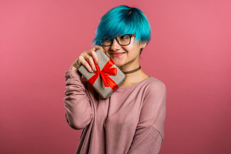 Portrait of a smiling young woman against red background
