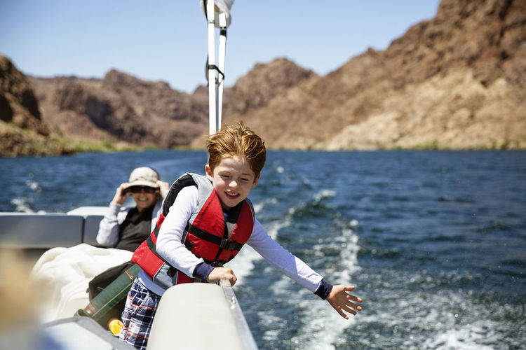 Happy boy traveling in boat with grandmother