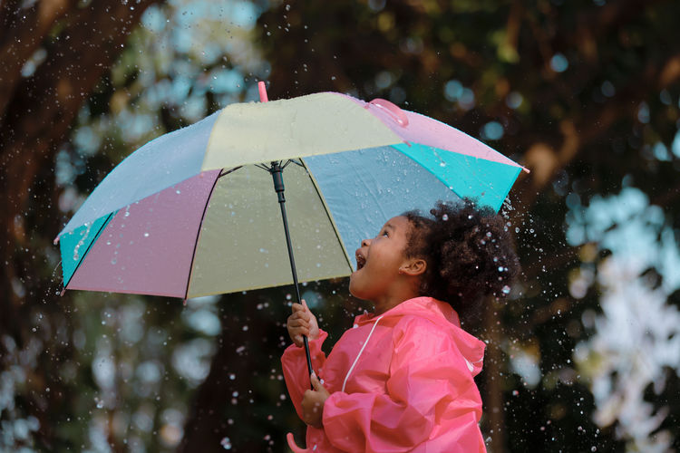 Woman holding wet umbrella during rainy season