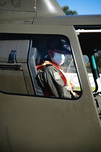 Rear view of man sitting in an helicopter