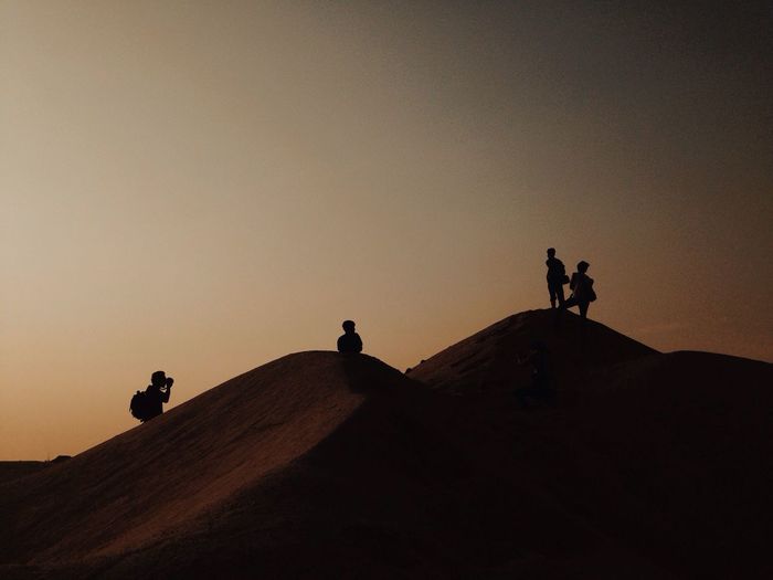 Low angle view of silhouette people at sunset