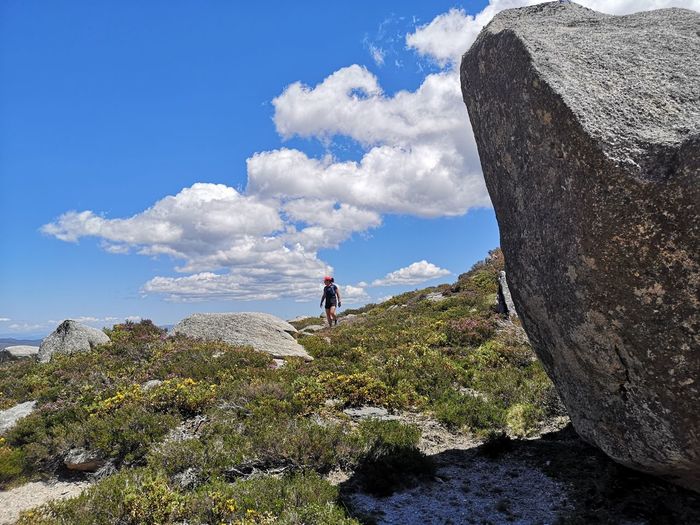 Man standing on rock against sky