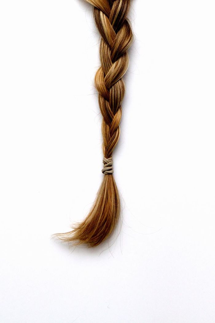 Blond braided hair against white background