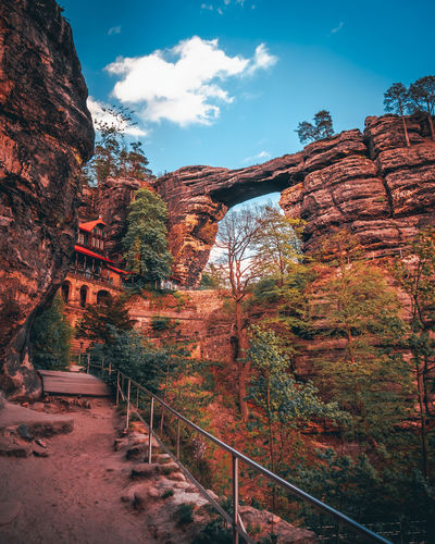 Scenic view of rock formation amidst trees against sky