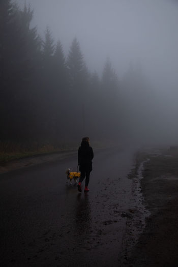Rear view of man and woman on road during winter