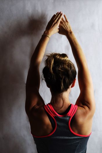 Rear view of woman standing against wall