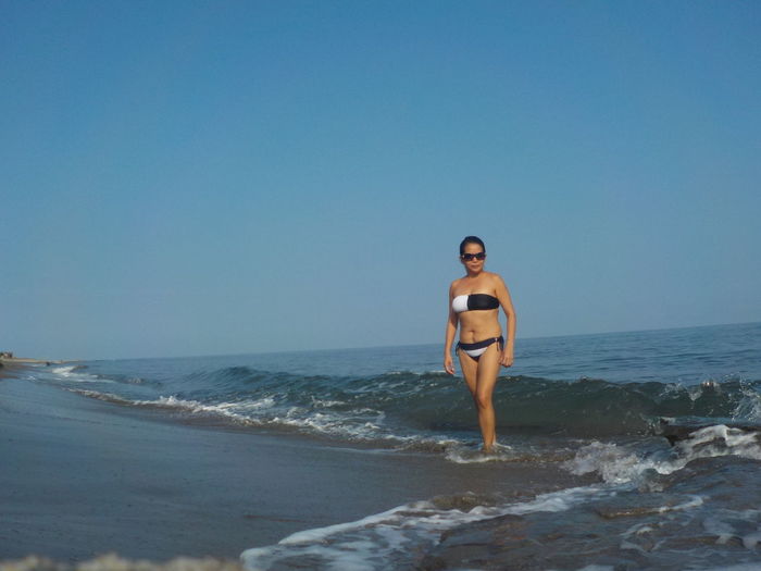 Full length of man on beach against clear sky