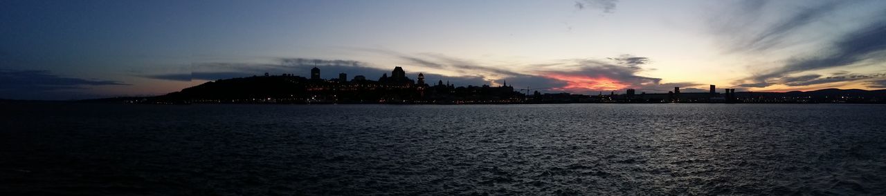 Silhouette of buildings against cloudy sky
