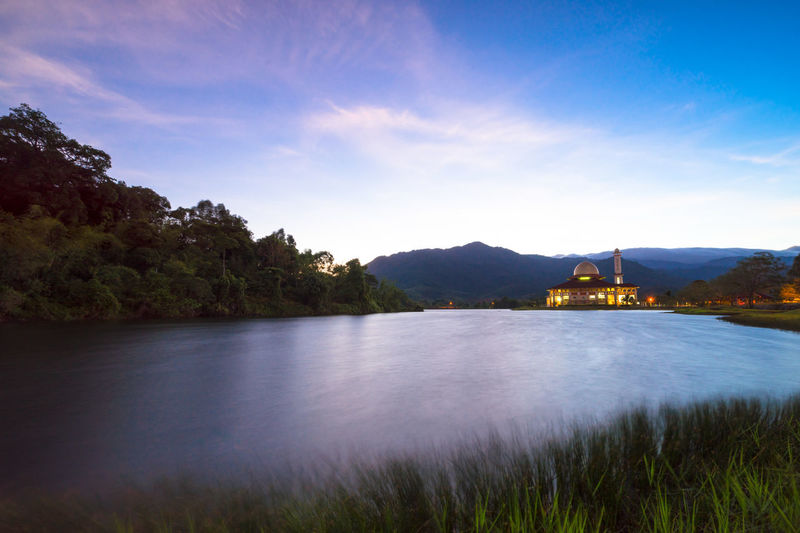 Scenic view of lake and mountains against sky at dusk