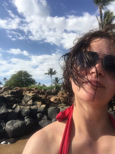 Midsection of woman at beach against sky