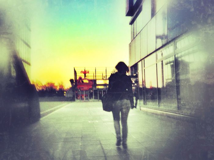 Woman standing in city at sunset