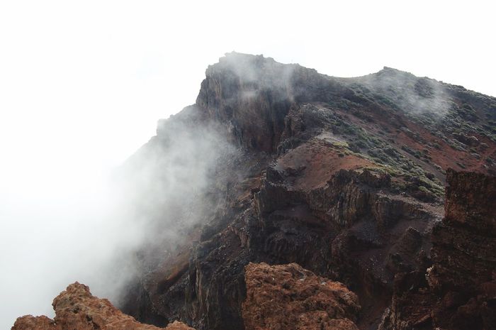 Low angle view of mountain in foggy weather