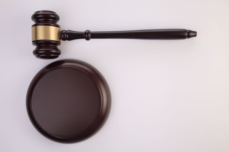 Close-up of gavel on wood against white background