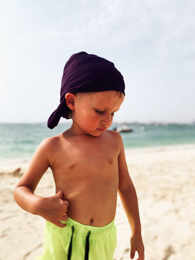 Little tanned boy at hot beach
