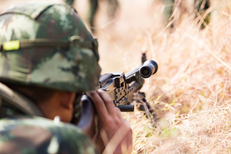 Close-up of army shooting with rifle