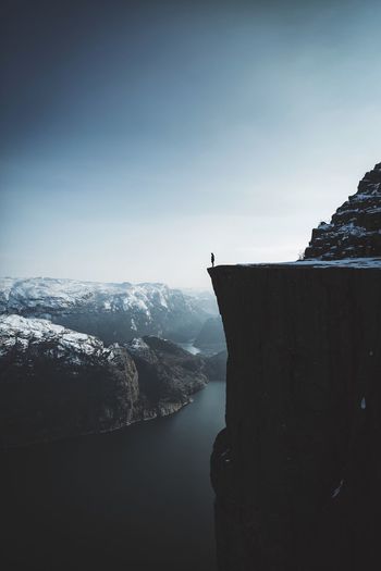 Scenic view of inlet amidst mountain against sky during winter
