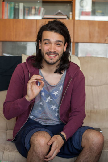 Portrait of smiling young man sitting on floor