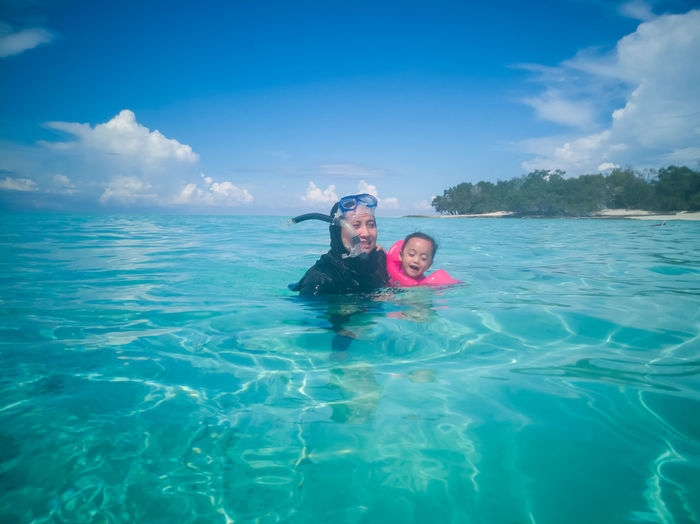Portrait of woman and daughter swimming in sea