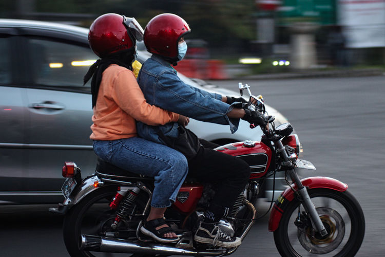 Side view of people riding motorcycle