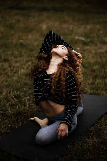 Young woman stretching on yoga mat