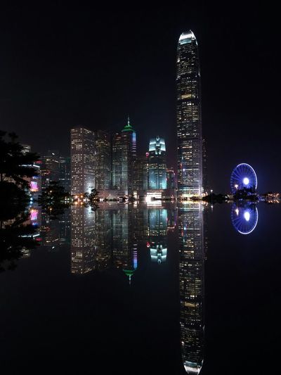 Reflection of two international finance center with modern buildings on sea