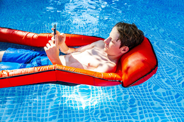 High angle view of man floating in swimming pool