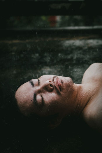 Portrait of shirtless man lying in water