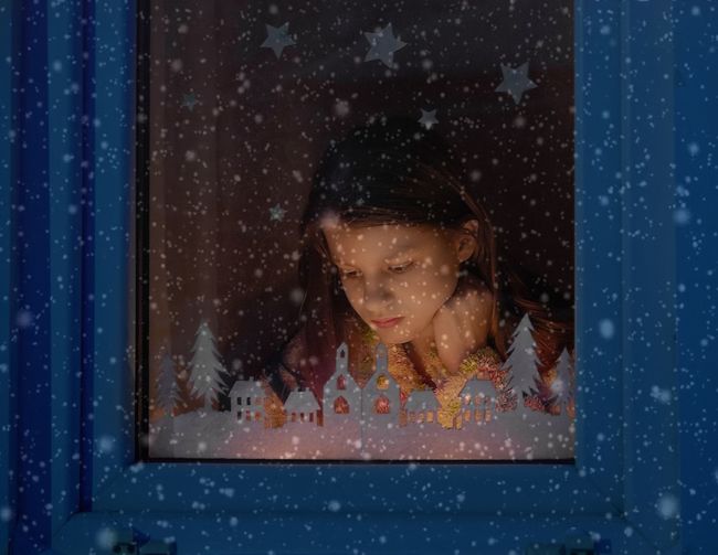 Close-up of girl looking through window