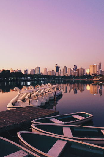 City buildings against clear sky at sunset by the lake in the park