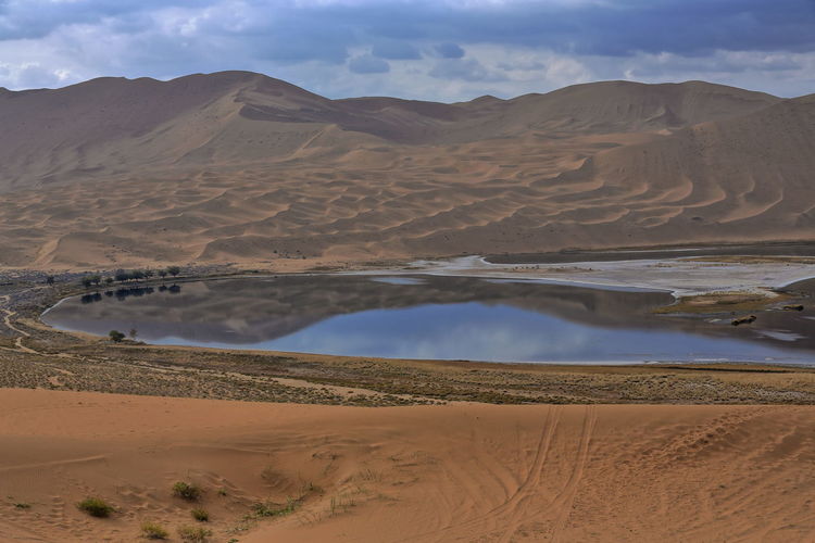 1097 yindeertu-yinderitu lake-badain jaran desert-dark water-cloudy sky-megadunes. nei mongol-china.