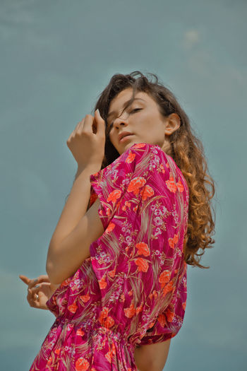 Low angle view of woman standing against the sky