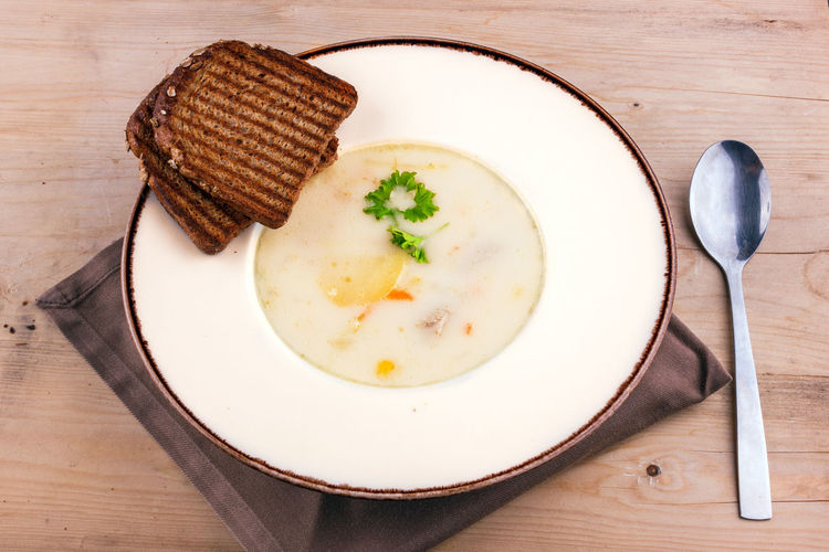 Cheese soup in clay plate with toasted bread