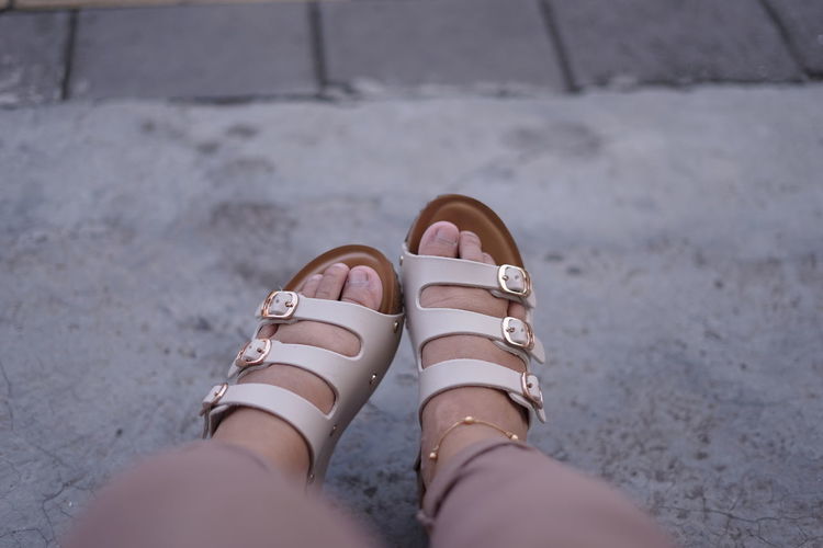 Low section of woman wearing sandals