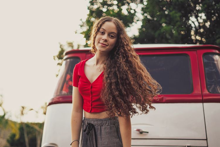 Portrait of teenager girl standing by van