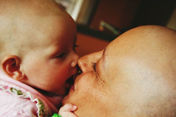 Close-up of woman kissing cute baby