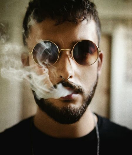 Close-up portrait of young man smoking