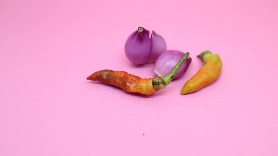 Close-up of fruits against pink background
