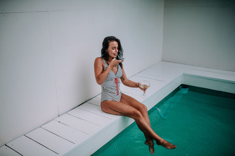 Full length portrait of young woman in swimming pool