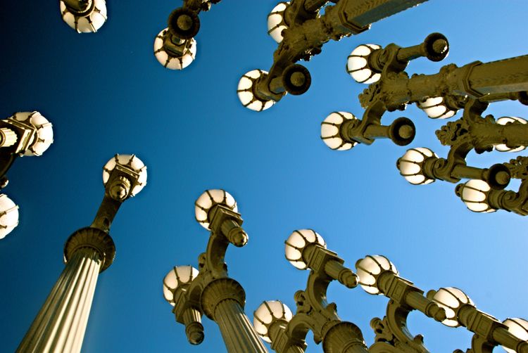 Low angle view of street lamps against clear blue sky