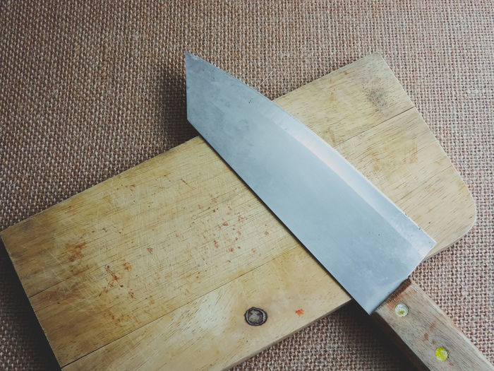 Directly above shot of meat cleaver with cutting board on burlap