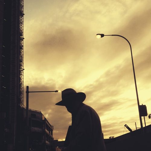 Silhouette man and cityscape against sky during sunset